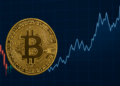a gold coin with a bitcoin sign on a graph